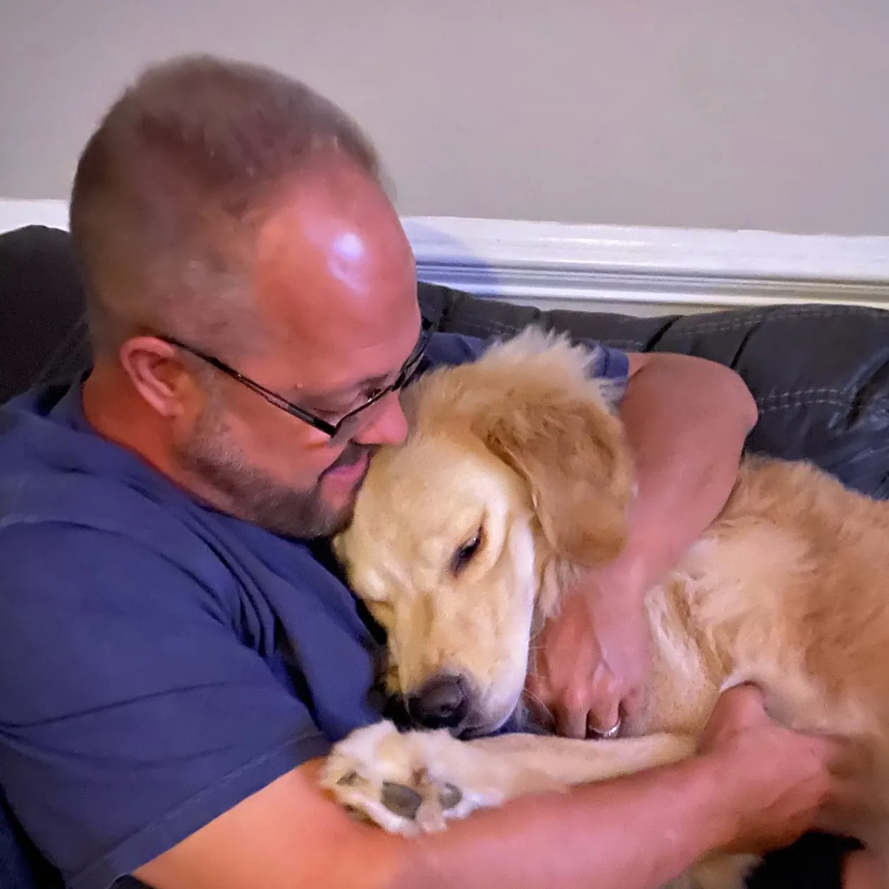 A veteran hugs his golden retriever service dog